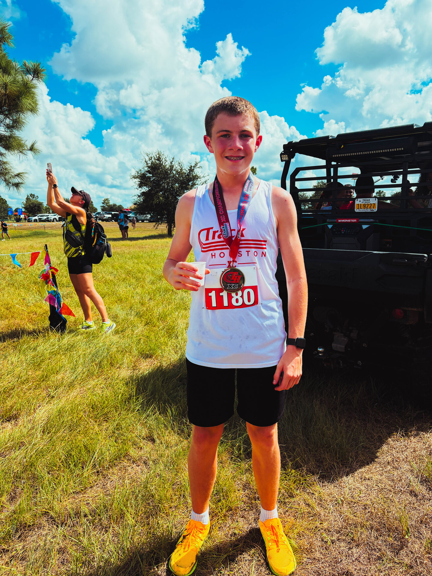 A Track Houston runner smiles with his medal after the cross country championship.